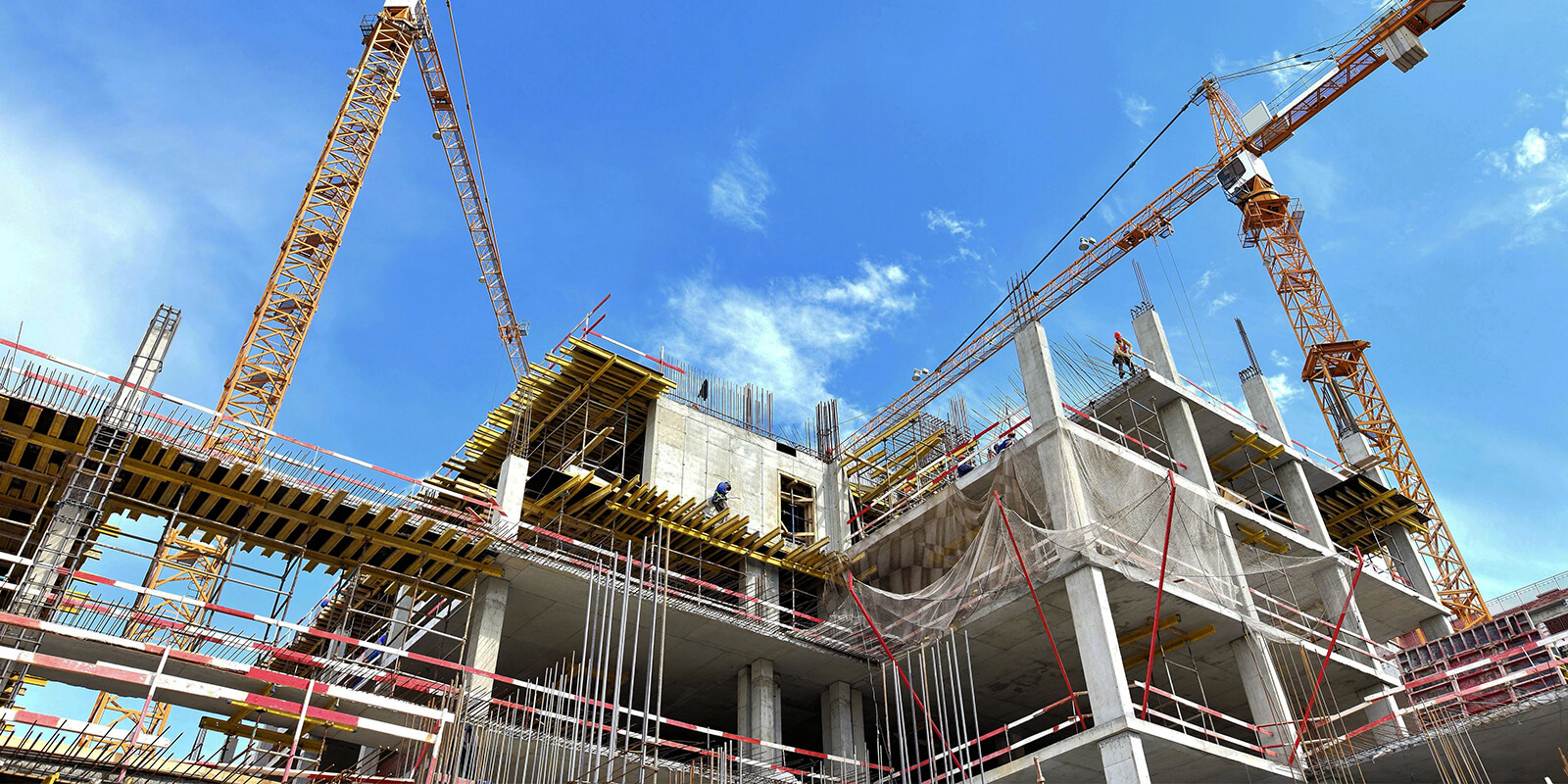 Active construction site with cranes and concrete structure